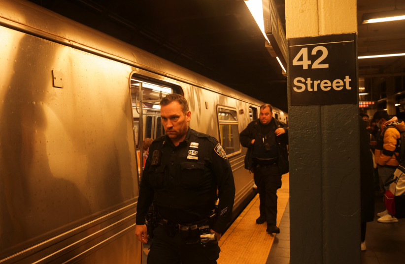  Police and security officers patrol Manhattan subways after a shooting at a subway station in the Brooklyn borough of New York City, New York, US, April 12, 2022. (photo credit: REUTERS/JEENAH MOON)