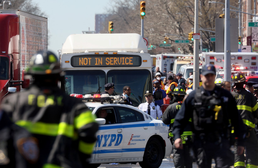  Law enforcement officers and firefighters work near the scene of a shooting at a subway station in the Brooklyn borough of New York City, New York, US, April 12, 2022.  (photo credit: REUTERS/BRENDAN MCDERMID)