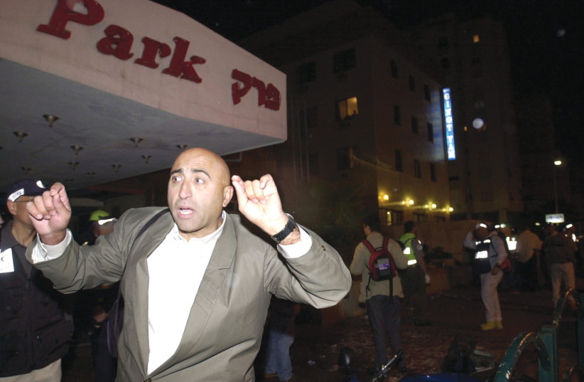  THE AFTERMATH: Reacting to the news of the terror attack at Netanya’s Park Hotel, March 27, 2002.  (photo credit: Scott Nelson/AFP via Getty Images)
