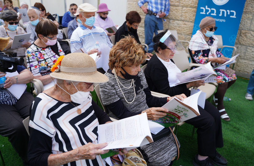  Retirement home residents peruse the Bayit Balev Haggadah at the celebration of its release. (photo credit: LIOR DASKAL)