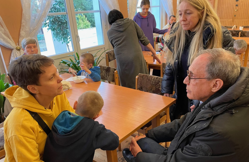  A UKRAINIAN WOMAN who fled Kharkiv holds one of her children as she meets with the writer at a refugee center run by the American Jewish Joint Distribution Committee in Poland, last month. (photo credit: DIASPORA AFFAIRS MINISTRY)