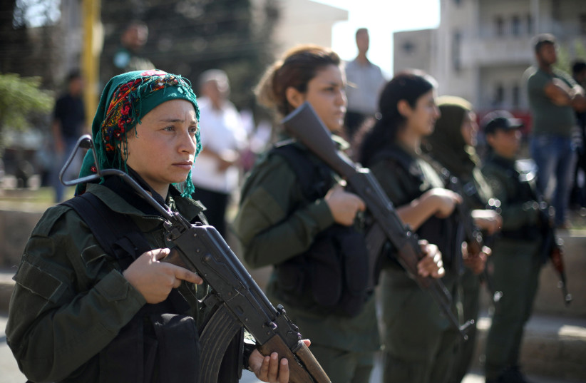  Kurdish policewomen stand guard as Kurdish and Arab protesters take part in a march against Turkish President and walk to the United Nations Headquarters in the town of Qamishli, Syria October 23, 2019.  (credit: REUTERS/MUHAMMAD HAMED)