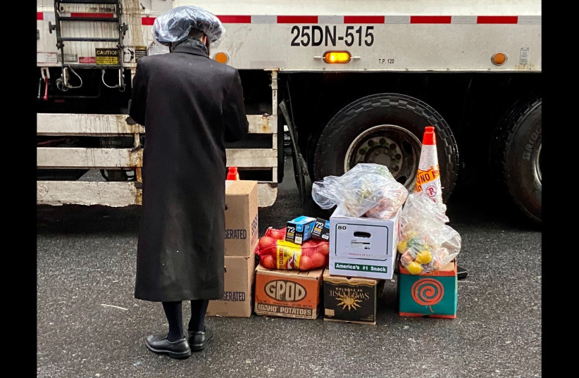  A Satmar Orthodox man volunteers to deliver free food provided by Met Council at a distribution center at the Brooklyn Navy Yard run by the United Jewish Organizations of Williamsburg, April 10, 2022.  (credit: Jacob Henry/JTA)