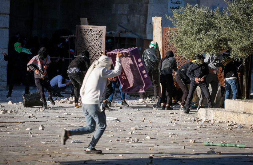  Palestinian protesters hurl stones towards Israeli security forces during clashes on the holy month of Ramadan at the Al-Aqsa mosque compound in Jerusalem's Old City on April 15, 2022.  (credit: JAMAL AWAD/FLASH90)