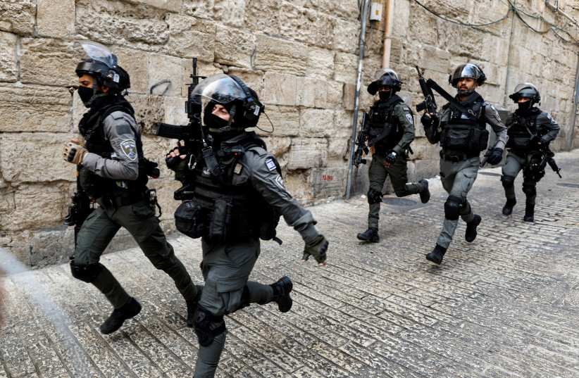  Israeli Border Police officers run in an alley in Jerusalem's Old City April 17, 2022. (photo credit: AMMAR AWAD/REUTERS)