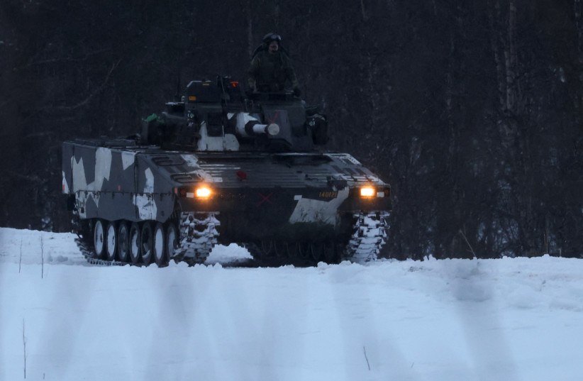  Swedish army members drive a an infantry fighting vehicle as part of military exercise called "Cold Response 2022", gathering around 30,000 troops from NATO member countries plus Finland and Sweden, amid Russia's invasion of Ukraine, in Setermoen in the Artic Circle, Norway, March 25 2022. (photo credit: YVES HERMAN/REUTERS)