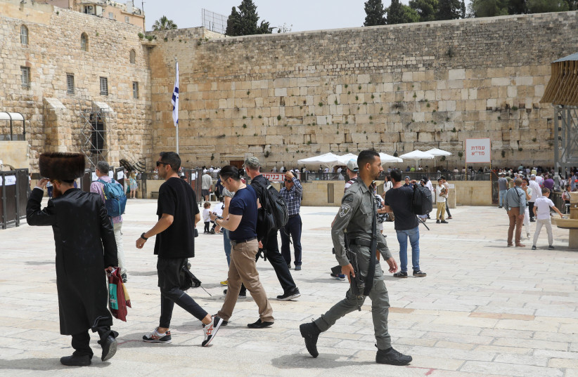 A Border Police officer is seen walking in Jerusalem's Western Wall on April 17, 2022 (photo credit: MARC ISRAEL SELLEM/THE JERUSALEM POST)