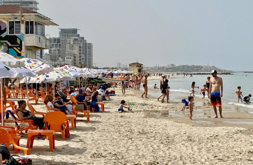  Israelis are seen visiting the beach in Tel Aviv amid a heatwave on the Passover holiday, on April 18, 2022. (photo credit: AVSHALOM SASSONI/MAARIV)