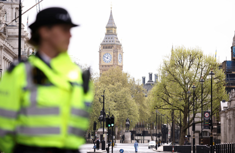  A forensic official and police officers work at a cordon on Whitehall in Westminster after the road was closed by police following an incident involving the arrest of a man near Downing Street, in London, Britain, April 18, 2022.  (photo credit: REUTERS/HENRY NICHOLLS)