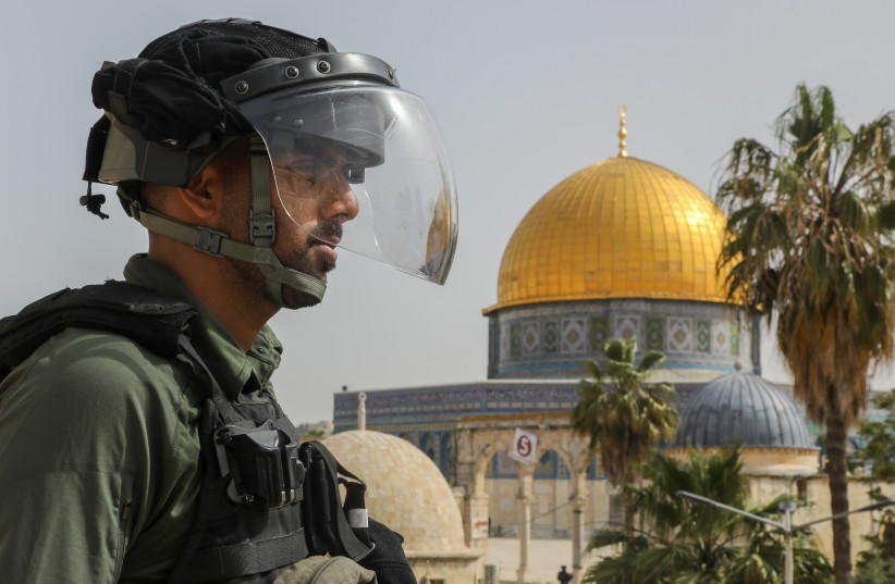  An Israeli security officer looks on at Dome of the Rock on Temple Mount in Jerusalem (credit: MARC ISRAEL SELLEM/THE JERUSALEM POST)