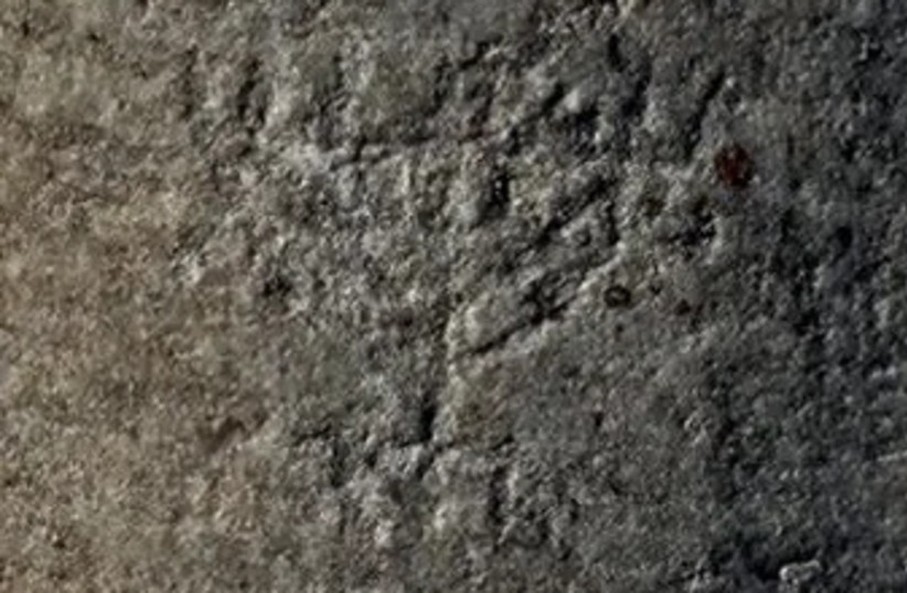  An image of menorah graffiti carved near a so-called brothel building in ancient Ephesus.  (credit: HASAN GULDAY)