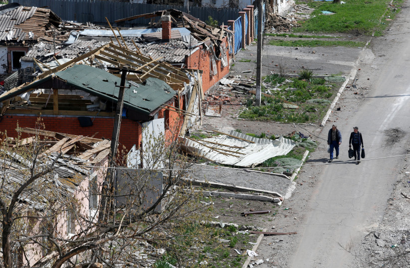  People walk near buildings damaged in the course of Ukraine-Russia conflict in the southern port city of Mariupol, Ukraine April 18, 2022 (photo credit: REUTERS/ALEXANDER ERMOCHENKO)