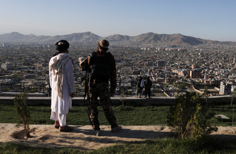 Taliban members are seen at the Taliban flag-raising ceremony in Kabul, Afghanistan, March 31, 2022.  (photo credit:  REUTERS/ALI KHARA)