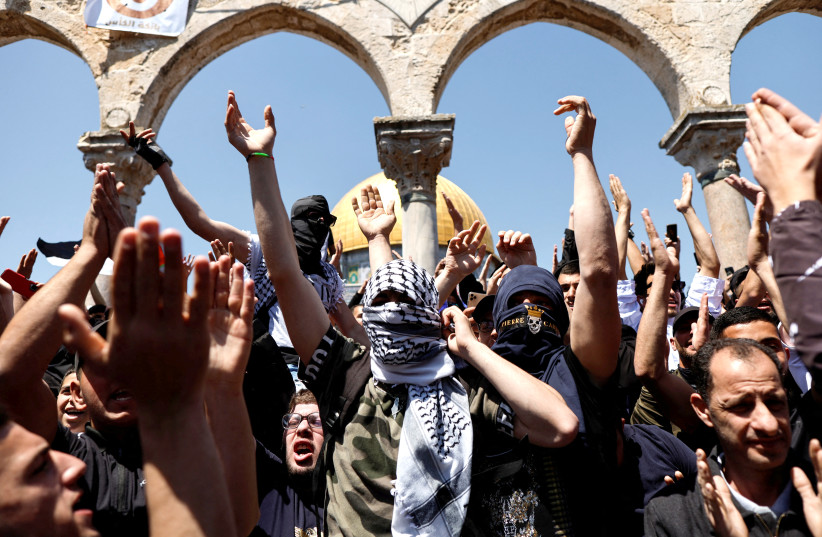  PALESTINIANS SHOUT slogans at al-Aqsa Mosque compound after riots and clashes with Israeli security forces last week.  (credit: AMMAR AWAD/REUTERS)