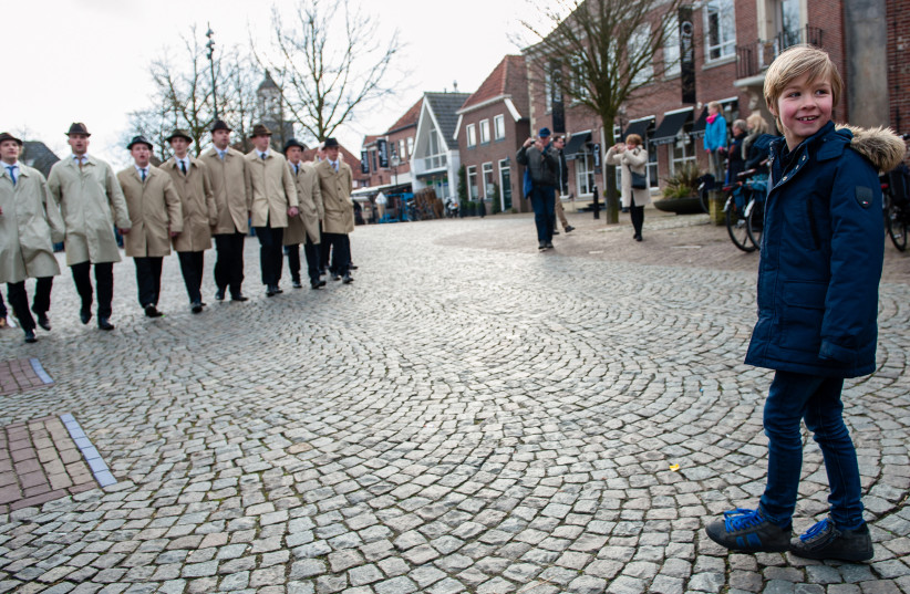  A boy approaches the singers of the traditional Easter caroling procession of Ootmarsum, the Netherlands, April 1, 2018. (photo credit: ROMY ARROYO FERNANDEZ / NURPHOTO)