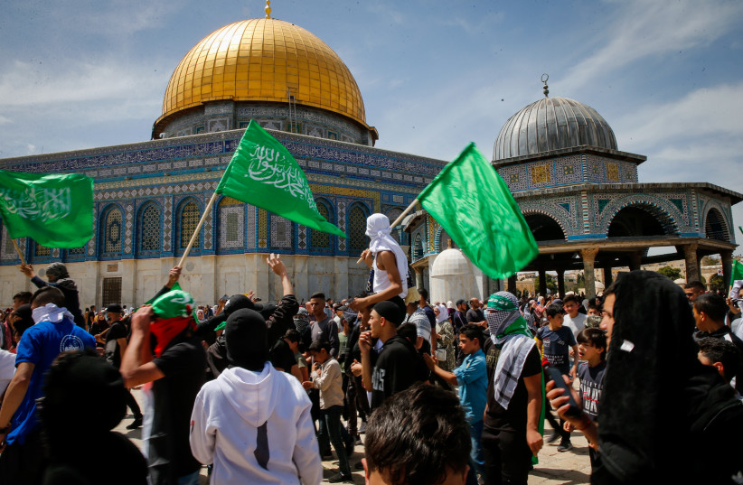  Protesters wave Hamas flags after Friday prayers of the holy month of Ramadan, at the Al Aqsa Mosque Compound in Jerusalem's Old City, Friday, April 22, 2022. (credit: JAMAL AWAD/FLASH90)