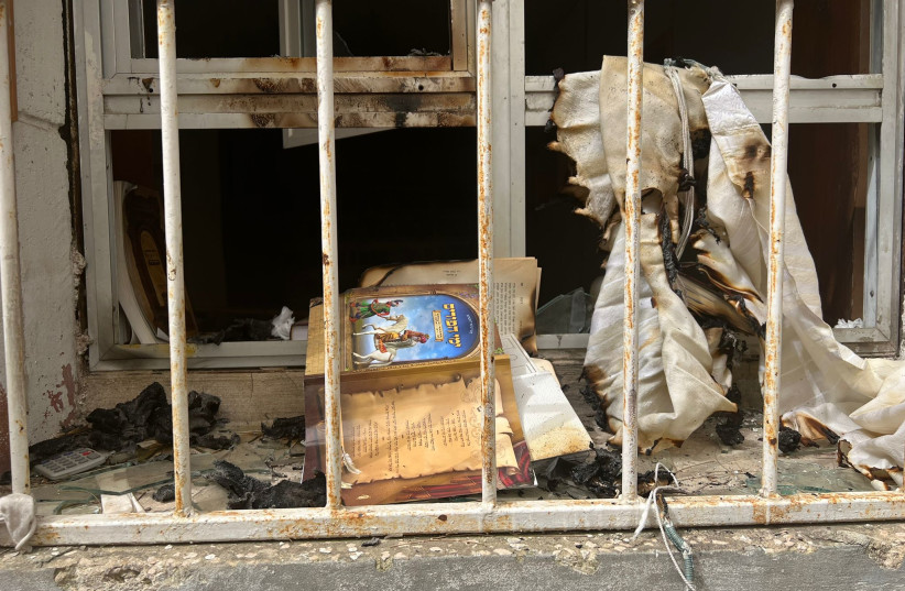  A burnt tallit and religious text is seen out the window of a synagogue set ablaze in Haifa on April 24, 2022  (photo credit: ISRAEL POLICE)