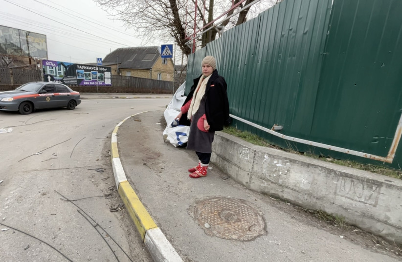 Iryna Abramova points to the spot where her husband was killed last month, and where his blood still stains the sidewalk in front of their home in Bucha, Ukraine on April 5, 2022. (photo credit: MOHAMMAD AL-KASSIM/THE MEDIA LINE)