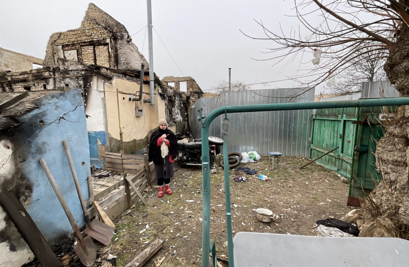 Iryna Abramova stands in the yard of her destroyed house in Bucha on April 5, 2022, a month after her husband’s covered body lay there before it was taken away by Ukrainian soldiers to the morgue in the capital, Kyiv. (credit: MOHAMMAD AL-KASSIM/THE MEDIA LINE)