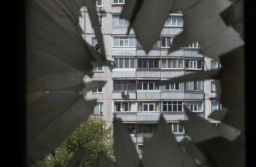  A damaged window is pictured at a burning residential building, following a Russian shelling amid Russia's attack on Ukraine, in Kharkiv, Ukraine, April 25, 2022. (credit: RICARDO MORAES/REUTERS)