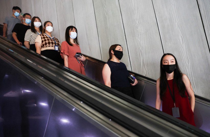  Office workers go for lunch at the central business district on the first day free of coronavirus disease (COVID-19) restrictions in Singapore April 26, 2022.  (photo credit: REUTERS/EDGAR SU)