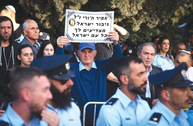  A MAN holds up a sign that reads ‘A hero of Israel: All of Israel salutes you’ at the funeral of policeman Amir Khoury, who was killed when he exchanged fire with an attacking terrorist in Bnei Brak last month (photo credit: David Cohen/Flash90)
