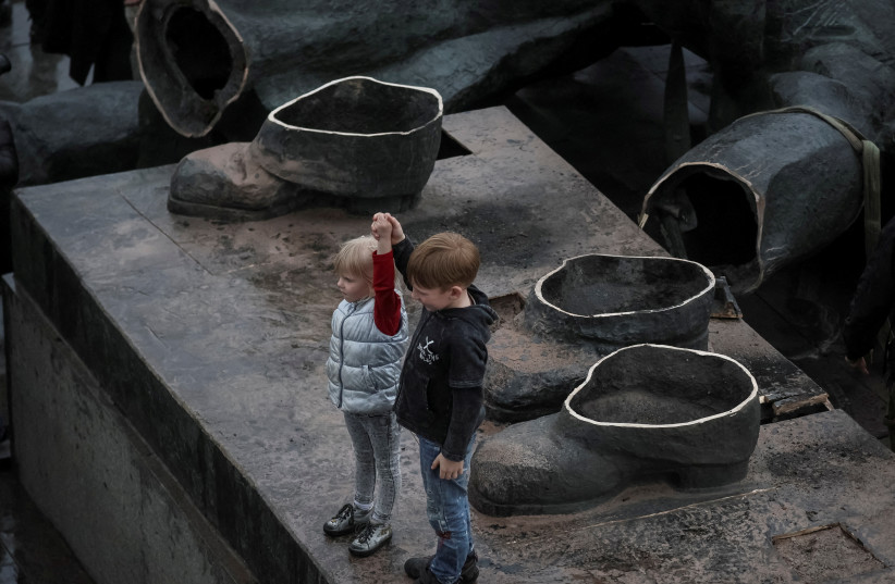  Children depict a Soviet monument to a friendship between Ukrainian and Russian nations after its demolition, amid Russia's invasion of Ukraine, in central Kyiv, Ukraine April 26, 2022.  (credit: REUTERS/GLEB GARANICH)