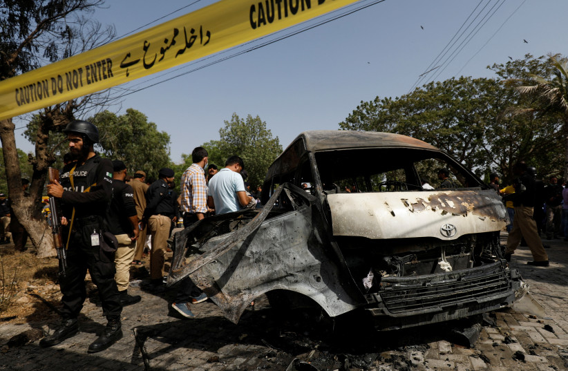  Police officers and crime scene unit gather near a passenger van, after a blast at the entrance of the Confucius Institute University of Karachi, Pakistan April 26, 2022.  (photo credit: REUTERS/AKHTAR SOOMRO)