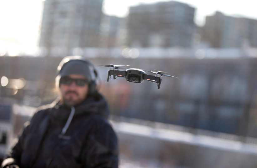  A drone operator flies his drone as Chinese drone maker DJI holds a demonstration to display an app that tracks a drone's registration and owner in Montreal (credit: REUTERS)