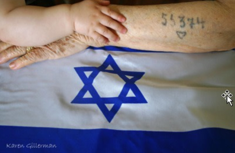  A A child holds a Holocaust survivor's arm on an Israeli flag (credit: Karen Gillerman)