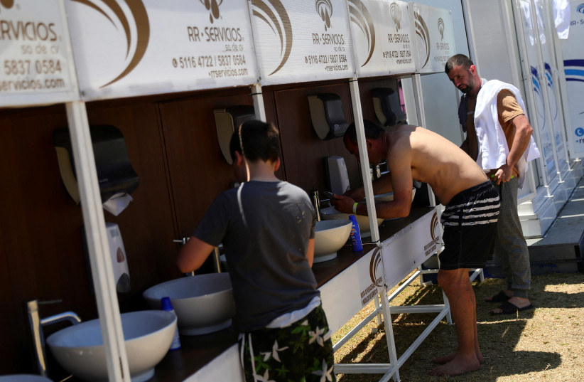 Ukrainians seeking asylum in the United States use sinks in the Francisco Madero sports complex, set up as a shelter by the local government, in the Iztapalapa neighbourhood in Mexico City, Mexico, April 27, 2022. (credit: REUTERS/EDGARD GARRIDO)