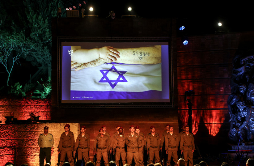  Israeli soldiers stand at the Holocaust Martyrs' and Heroes Remembrance Day opening ceremony in memory of the six million Jewish men, women and children murdered by the Nazis and their collaborators, at Yad Vashem Holocaust Museum in Jerusalem April 27, 2022 (photo credit: REUTERS/Ronen Zvulun)