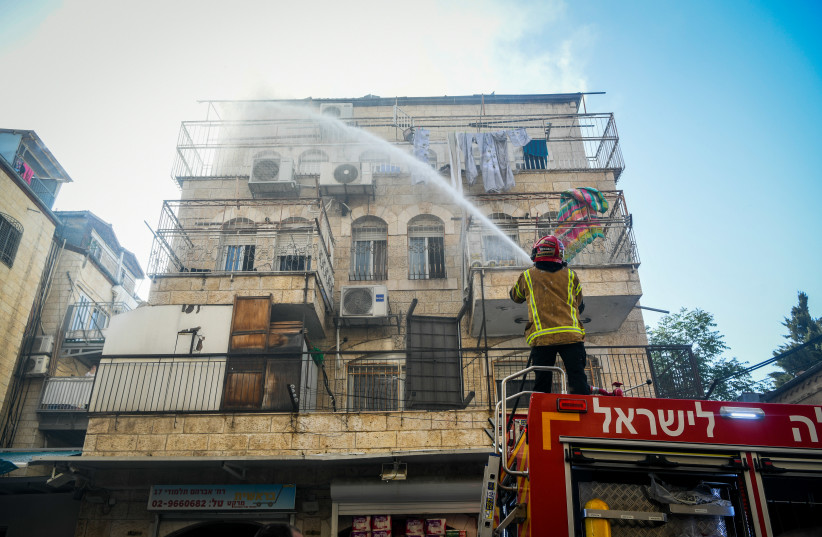  Firefighters and police at the scene where a fire broke at an apartment in Jerusalem, April 28, 2022. (photo credit: Arie Leib Abrams/Flash90)
