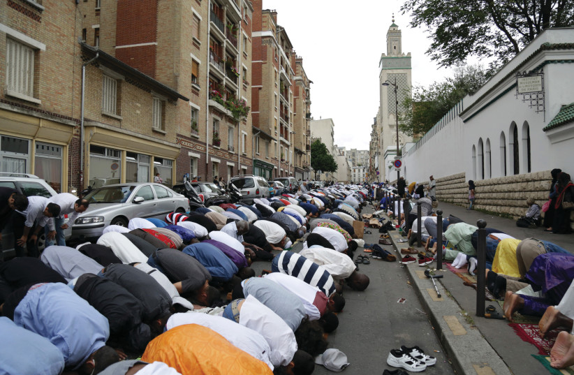  PRAYING DURING Eid al-Fitr outside the Great Mosque of Paris. (photo credit: Zakaria Abdelkafi/AFP via Getty Images)
