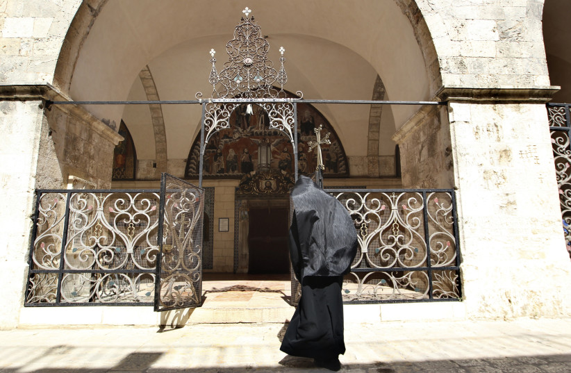  AN ARMENIAN priest enters a church at the monastery compound in the Armenian Quarter in Jerusalem’s Old City.  (photo credit: AMMAR AWAD/REUTERS)