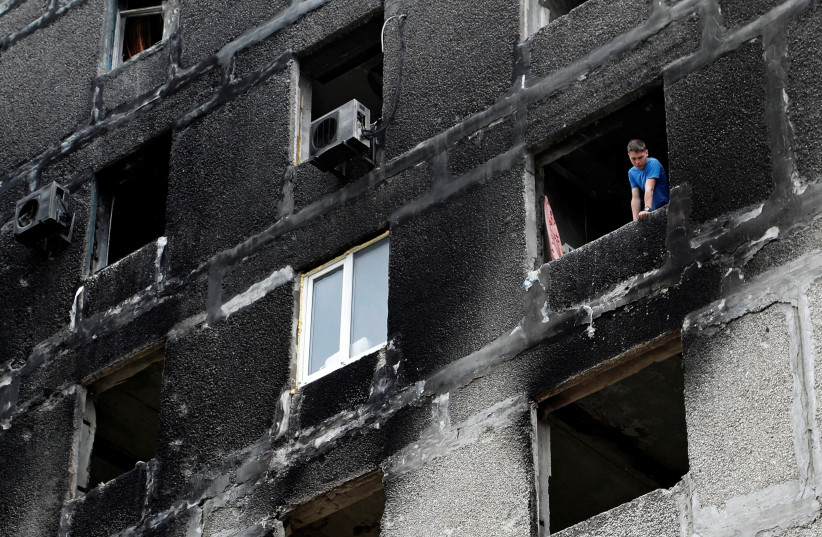  A local resident is seen inside a damaged apartment building in Mariupol. (credit: REUTERS/ALEXANDER ERMOCHENKO)