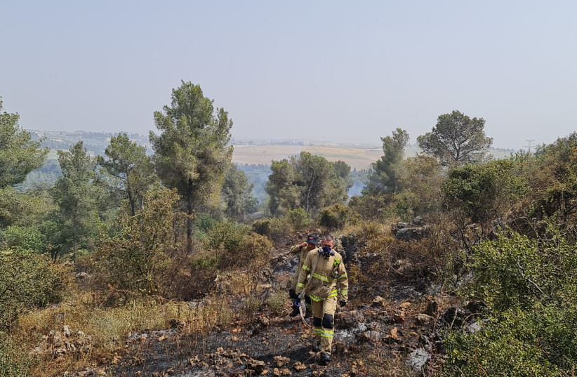  A firefighter walks amid charred ground in a fire near Elyakim on Saturday, April 30, 2022. (credit: FIRE AND RESCUE NORTHERN DIVISION)
