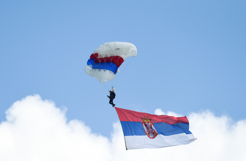  A paratrooper carries the flag of Serbia during a demonstration of the Serbian Army's air defence capabilities, "Shield 2022", at the military airport "Colonel-pilot Milenko Pavlovic" in Batajnica, near Belgrade, Serbia, April 30, 2022. (photo credit:  REUTERS/ZORANA JEVTIC)