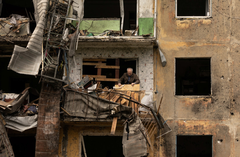  A man stands on the balcony of his apartment after a missile strike damaged a residential building, amid Russia's invasion, in Dobropillia, in the Donetsk region, Ukraine, April 30, 2022 (credit: REUTERS/JORGE SILVA)