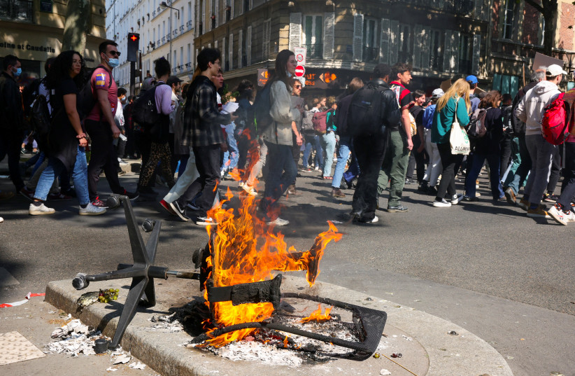  A fire of burning trash is seen during the traditional May Day labour union march in Paris, France, May 1, 2022 (photo credit: REUTERS/SARAH MEYSSONNIER)