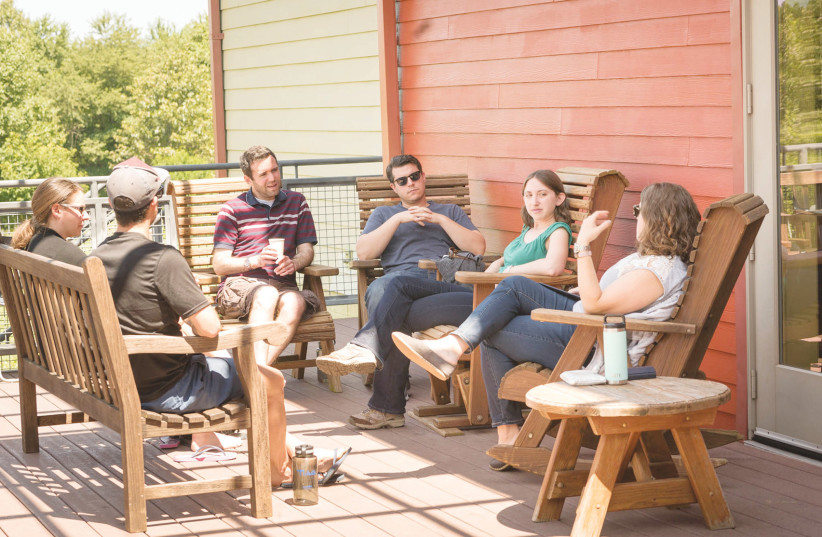  A SMALL GROUP meets at GatherDC’s immersive retreat Beyond the Tent, which brings 25 Jews in their 20s and 30s to explore their connection to Jewish life and helps build relationships to help them live out that Jewish life. (photo credit: Gather, Inc.)