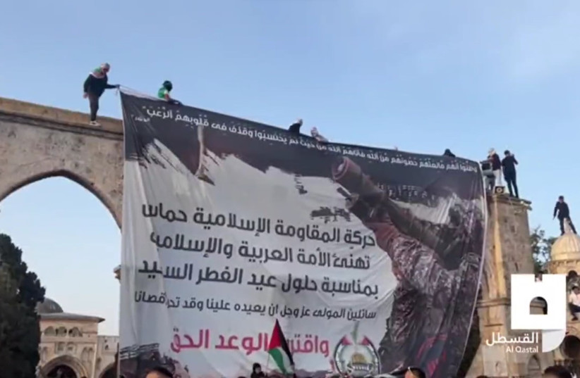  Footage of a Hamas banner featuring a greeting for Eid al-Fitr and a photo of a Hamas terrorist, May 2, 2022 (photo credit: Screenshot from video shared by Al-Qastal)