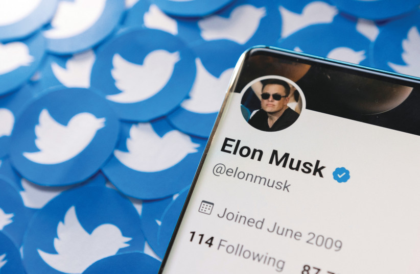  ELON MUSK’S Twitter profile is seen on a smartphone placed on printed Twitter logos in this picture illustration. (photo credit: DADO RUVIC/REUTERS)