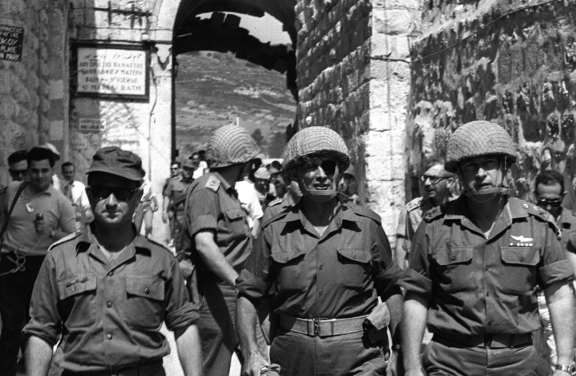 THEN-DEFENSE MINISTER Moshe Dayan (center), then-IDF chief of staff Yitzhak Rabin (right) and then-OC Central Command Uzi Narkiss walk through Lions' Gate into Jerusalem's Old City in June 1967 during the Six Day War. Dayan demanded the Israeli flag at the Temple Mount be lowered. (photo credit: ILAN BRUNER/GPO)