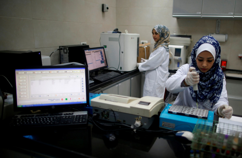  Palestinian technicians work in a laboratory at Al Awda Hospital, a private medical facility in the northern Gaza Strip, March 30, 2017 (photo credit: MOHAMMED SALEM/REUTERS)