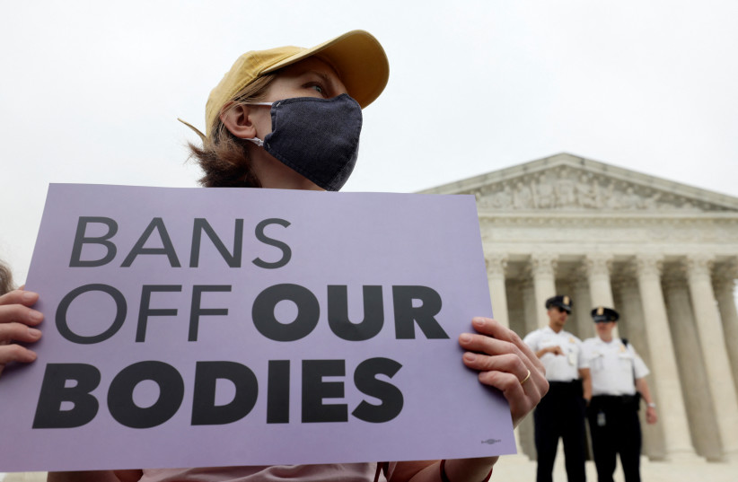 A demonstrator holds a sign during a protest outside the US Supreme Court, after the leak of a draft majority opinion written by Justice Samuel Alito preparing for a majority of the court to overturn the landmark Roe v. Wade abortion rights decision later this year, in Washington, US, May 3, 20 (photo credit: REUTERS/EVELYN HOCKSTEIN)