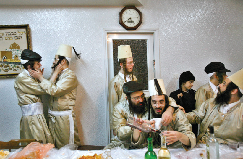 Haredim drink alcohol while celebrating Purim in Jerusalem. (photo credit: GIL COHEN/REUTERS)