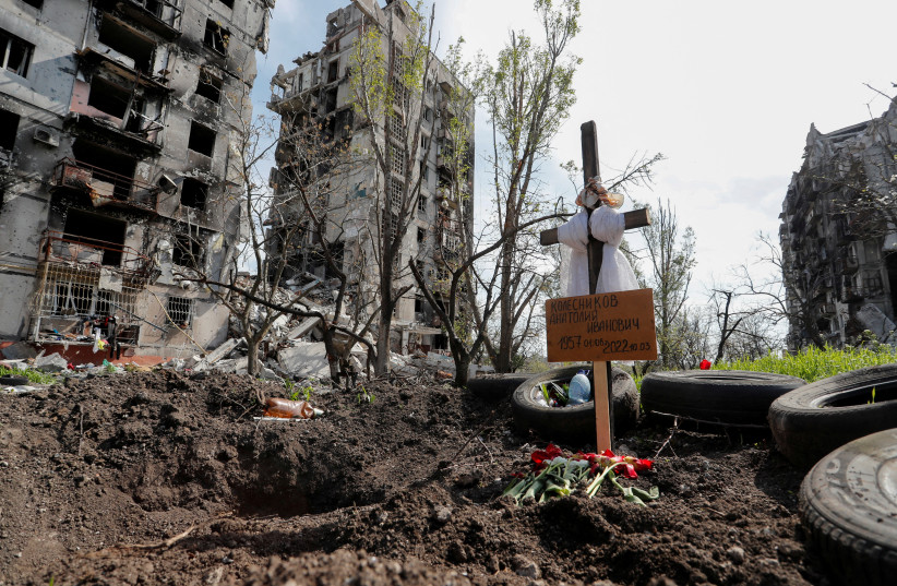 A view shows a graves of a civilian killed during Ukraine-Russia conflict in the southern port city of Mariupol, Ukraine May 3, 2022. A grave board reads: "Kolesnikov Anatoly Ivanovich". (photo credit: REUTERS/ALEXANDER ERMOCHENKO)