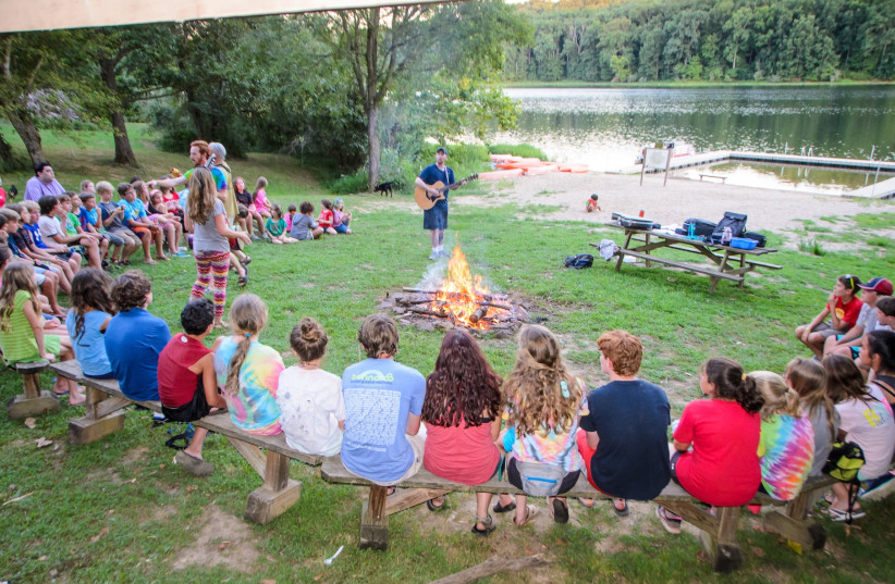  Campers and staff gather around the bonfire at Camp Manitowa, the host site of Camp Indigo Point. (credit: DAN GRABEL)