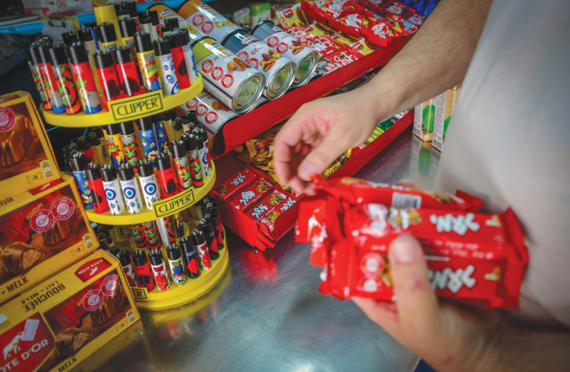  A CLERK removes Elite candy bars from the shelves last week, following the discovery of salmonella on the production line at a Strauss/Elite factory in the Galilee. (credit: AVSHALOM SASSONI/FLASH90)